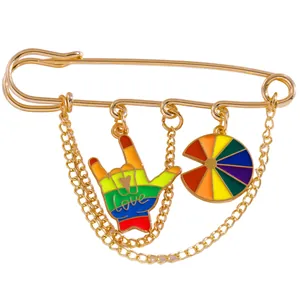 Golden pride brooch featuring rainbow love charm and multi-layered metallic chains