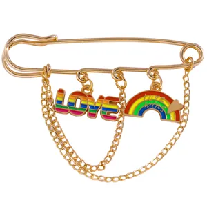 Golden safety pin brooch with rainbow LOVE charms and Love Wins pendant details