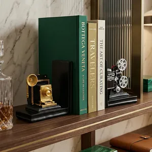 Pair of vintage camera bookends in black and gold on a bookshelf for office decor