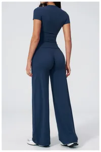 Rear view of dark blue athletic set featuring tight short sleeve top and wide leg pants