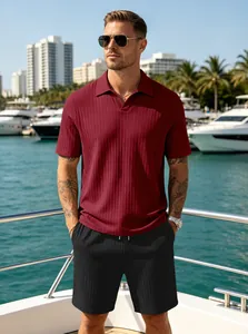 Close-up of men's burgundy ribbed knit polo and black drawstring shorts on a luxury yacht