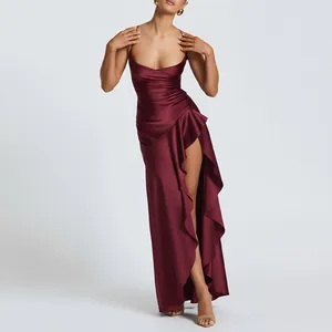 Detail of burgundy satin dress with thin straps, ruched waist and side slit with ruffles