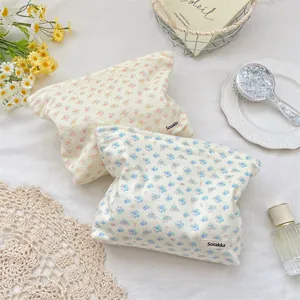 Detailed macro view of corduroy floral makeup bags with soft texture and side brand tags