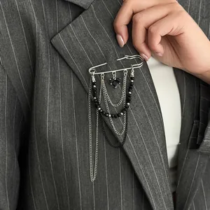 Silver multi-layer brooch pin with chains, black beads and heart pendant on a suit