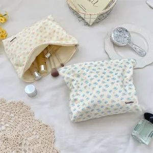 Macro shot of floral corduroy makeup bags with gold zipper and woven brand label