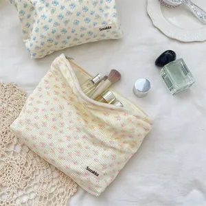 Floral corduroy cosmetic bags in blue and yellow showing large capacity and texture