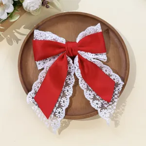 Detailed texture of red satin and floral lace layers on the spring hair clip
