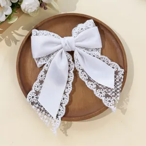 Macro detail of elegant white lace bow hair clip on a wooden tray with dried flowers