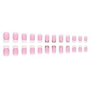 Coffret de faux ongles French roses avec paillettes et motifs de cœur sur fond blanc