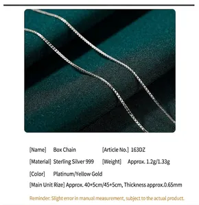 Detailed view of 999 sterling silver box chain necklace on green silk fabric