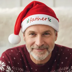 Detail of plush Christmas hat with 'father' embroidery and holly leaf pattern