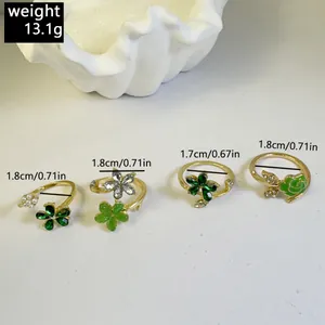 Vista de detalle de juego de cuatro anillos dorados con flores y perlas blancas