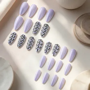 Macro shot of long almond lavender press-on nails with cute black panda print details