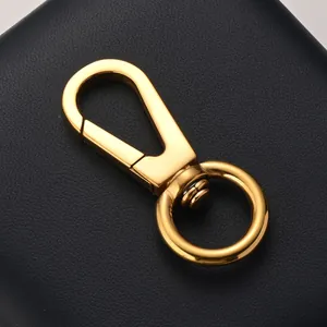 Polished gold swivel lobster clasp for keychain and bag accessory on leather background