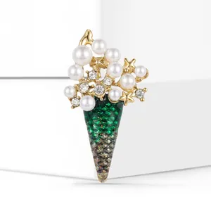 Détail macro d'une broche sapin de Noël avec perles, strass et émail vert