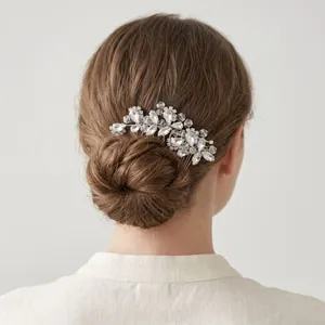 Détail d'un peigne à cheveux argenté pour mariée avec cristaux et motif floral