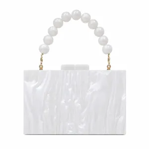 Detailed macro view of white pearlescent acrylic evening bag with beaded handle