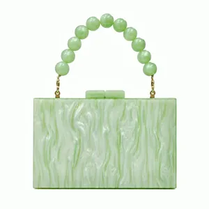 Detail of green marble acrylic evening bag with frosted bead wrist handle and gold clasp