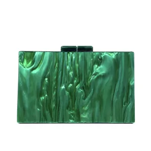 Detail of green marble acrylic evening clutch bag with rectangular buckles on white back