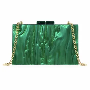 Close-up of emerald green marbled acrylic evening bag with a gold chain strap