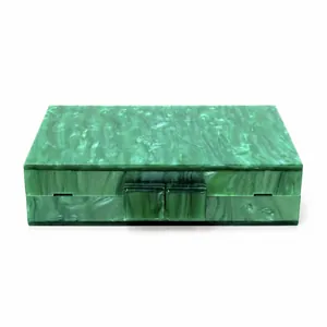 Detail of green marbled acrylic evening bag showing smooth resin texture and square clasps