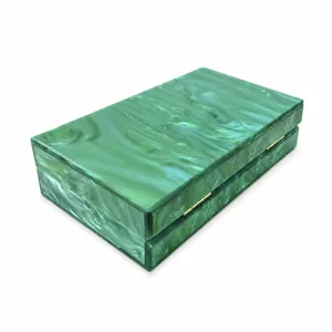 Detail view of green marble acrylic clutch bag with secure gold metal side hinges