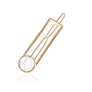 Macro shot of geometric gold alloy hair clip with white marble pattern stone inlay