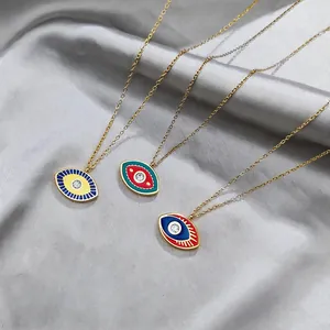Detailed close-up of three colorful Evil Eye necklaces on silver satin fabric