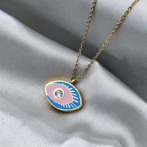 Detail of evil eye pendant with pink center and blue enamel on gold chain necklace