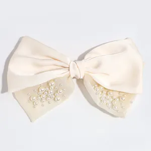 Elegant cream satin bow hair clip with decorative pearls and shimmering mesh detail