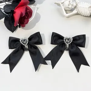 Detail of gothic black satin bow hair clips with heart rhinestone and black water drop gemstone