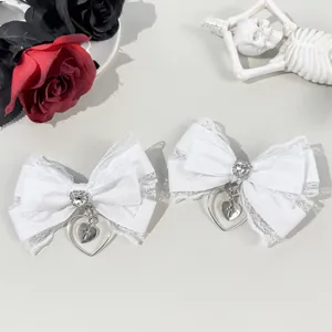Detail of white lace hair clips with heart cross pendants and gothic rose decor