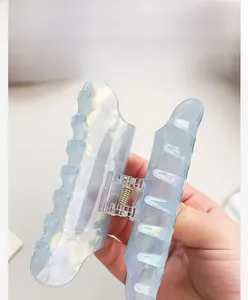 Macro shot of iridescent light blue hair claw clip with wave design and metal spring