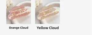 Detail of pearlescent cloud-shaped hair claws in orange and yellow finishes