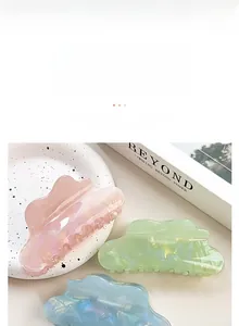 Detailed view of pastel cloud hair claws with pearlescent marble texture for women