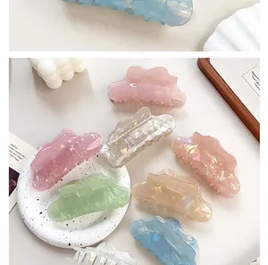 Detailed view of pearlescent cloud-shaped hair claws in assorted macaron pastel colors