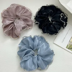 Detail of satin scrunchies with bead-stitched edges in pink, black, and blue