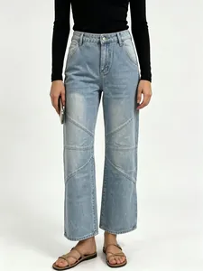 Close-up of geometric paneled stitching and washed denim texture on wide leg jeans