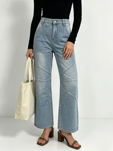 Detail of light blue straight-leg jeans with unique geometric patchwork stitching design