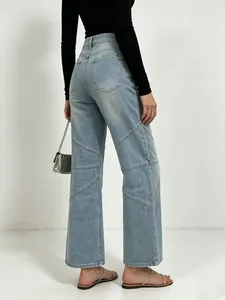 Detail showing diagonal seam patchwork and high-waist design on light blue wide-leg jeans