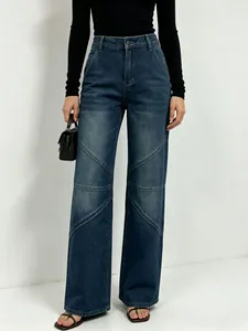 Detail of diagonal patchwork stitching on dark blue vintage washed wide leg jeans