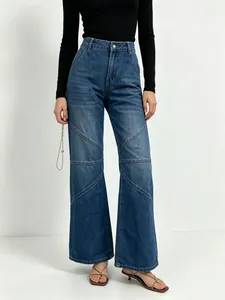 Detail of high waist blue wide leg jeans featuring geometric stitching and washed denim