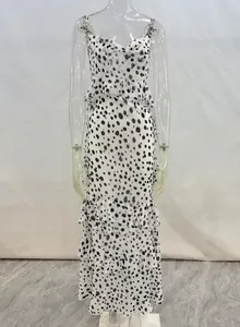 Detailansicht der gestuften Rüschen und des Punktemusters auf dem weißen Chiffon-Maxikleid