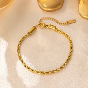 Close-up of golden twist rope bracelet with lobster clasp on silk background