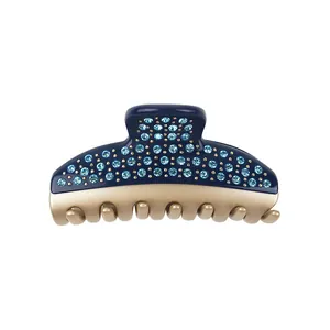 Detail of navy blue hair claw with sparkling light blue rhinestones and gold-tone teeth