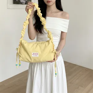 Detail of light yellow ruched cloud strap and colorful beads on a canvas bag