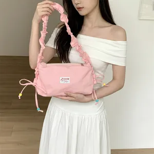 Detail view of pink pleated canvas shoulder bag with decorative colored beads