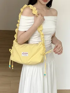 Stylish yellow canvas crossbody bag with pleated ruffle shoulder strap and bead detail