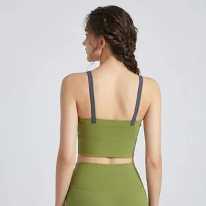 Dettaglio del reggiseno sportivo incrociato verde oliva con spalline grigie a contrasto