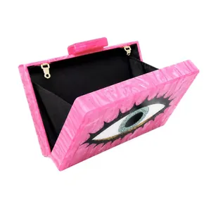 Detailed macro view of pink marble acrylic evening bag with evil eye design and golden hooks